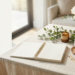 Size: 1200 × 628 pixels Aspect Ratio: 1.91:1 Prompt: Create a luxury lifestyle featured image for a blog post titled: "Simple Wellness Routines for Busy Women: Small Habits That Create a Healthier, More Peaceful Life" Style: Quiet Luxury • Organic Modern • Feminine Wellness • Faith-Inspired Lifestyle • Minimalist Elegance • Premium Editorial Photography Scene: Create a peaceful morning wellness scene featuring an elegant Gratitude & Grace Spiral Journal as the main focal point. Place a beautiful spiral journal notebook on a soft linen-covered natural wood table in a bright, calming home environment. Include thoughtful wellness elements: Open gratitude journal with blank pages Elegant pen Fresh white flowers or peonies Eucalyptus greenery Ceramic tea cup Healthy breakfast elements such as fresh fruit or herbal tea Small candle Soft linen textures Natural wood accents Mood: The image should communicate simple daily wellness routines, gratitude, self-care, balance, peace, and intentional living. Create the feeling of a woman beginning her day with calm moments of reflection and healthy habits. Color Palette: Warm ivory, cream, beige, soft sage green, muted blush, natural wood, and subtle gold accents. Composition: Make the Gratitude & Grace Spiral Journal the hero element. Show the spiral binding naturally. Leave clean negative space on the left side for blog title text. Use soft morning sunlight. Create a high-end wellness magazine aesthetic. Make the scene warm, inviting, and inspirational. Important Requirements: No people No hands No logos No brand names No readable text on journal pages No product mockup No 3D rendering No clutter No overly staged appearance Professional editorial quality Optimized for WordPress featured image and Pinterest Image Text Area (do not add text): Reserve space for: Simple Wellness Routines for Busy Women Small Habits for a Healthier, More Peaceful Life SEO Image Alt Text: Gratitude and Grace Wellness Journal with peaceful self-care elements representing simple wellness routines, healthy habits, and intentional living for busy women